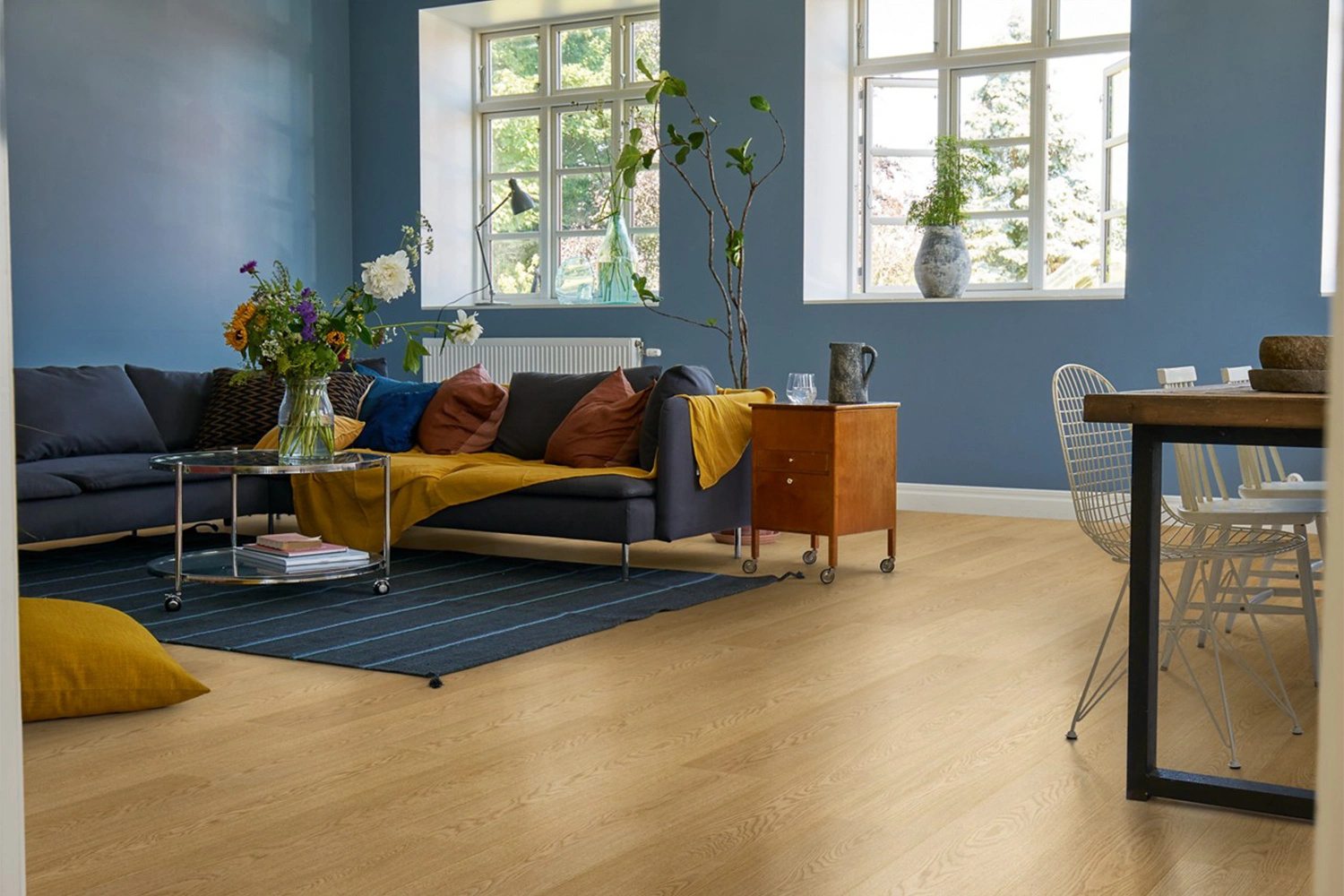 Nowoczesny salon z jasną podłogą laminowaną i niebieskimi ścianami